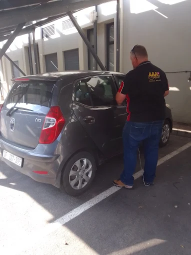 AAA Locksmiths technician attending to a parked vehicle