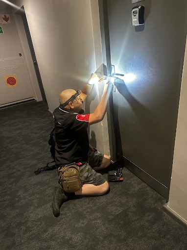AAA Locksmiths technician working on an apartment door lock